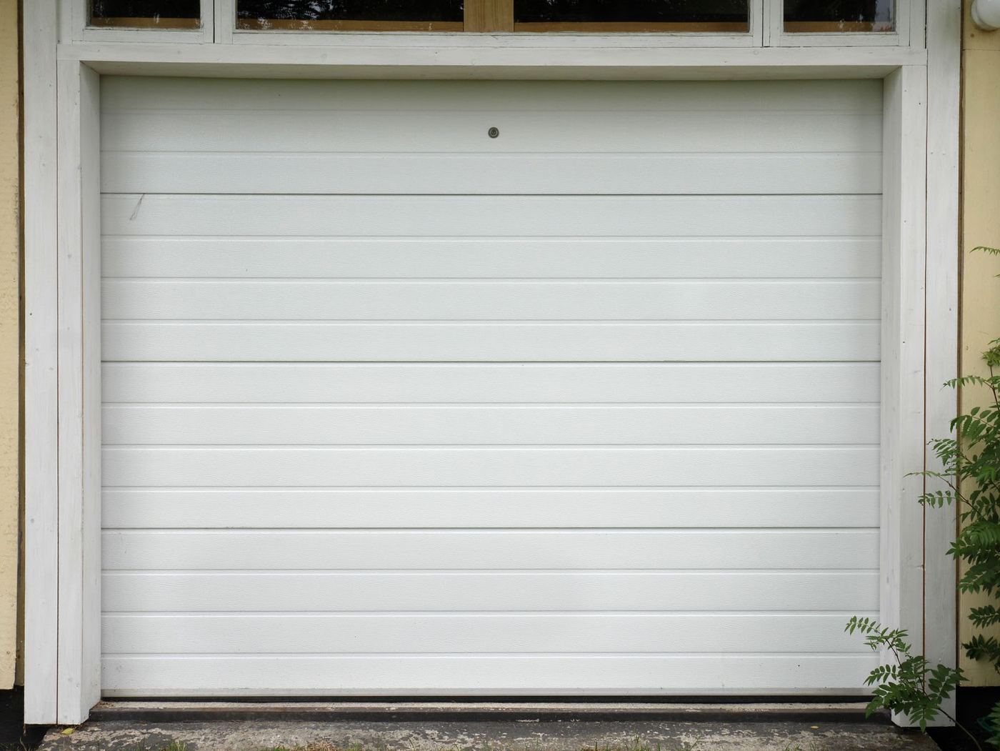 A clean white sectional garage door, close-up